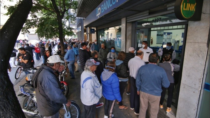 Expuestos al virus: multitud de gente espera cobrar en los bancos. 