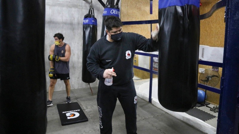 El boxeador Matías Vidondo desinfectando uno de las bolsas de boxeo. 
