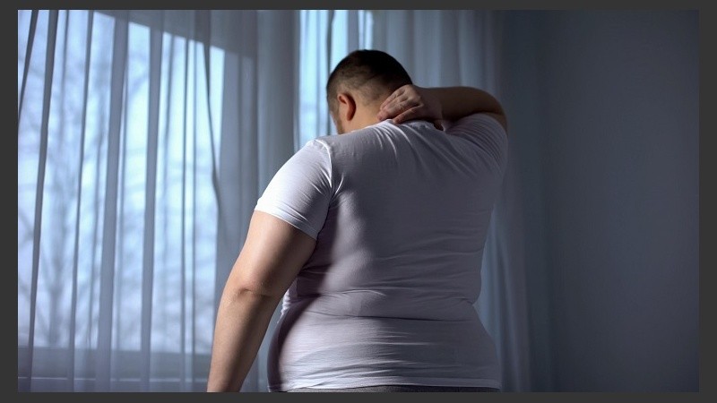 Obese man stretching neck muscles, back pain problems caused by overweight